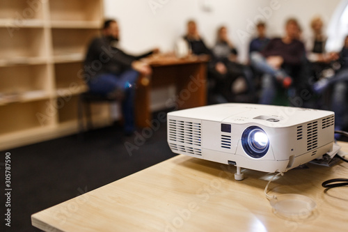 LCD video projector at business conference or lecture in a conference room or office with blurred people background photo