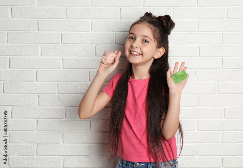 Little girl with slime near white brick wall Little girl with slime near white brick wall