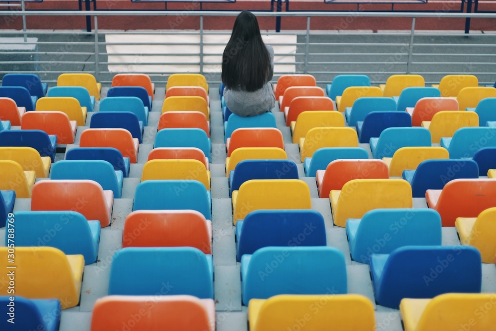 Sensual portrait of beautiful young girl walking in the old abandoned stadium on cold autumn day