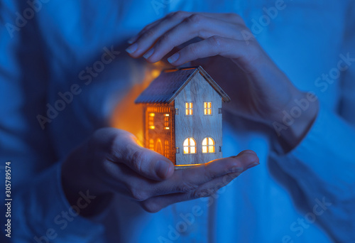 concept technology protection of the house from the cold. house in caring female hands photo