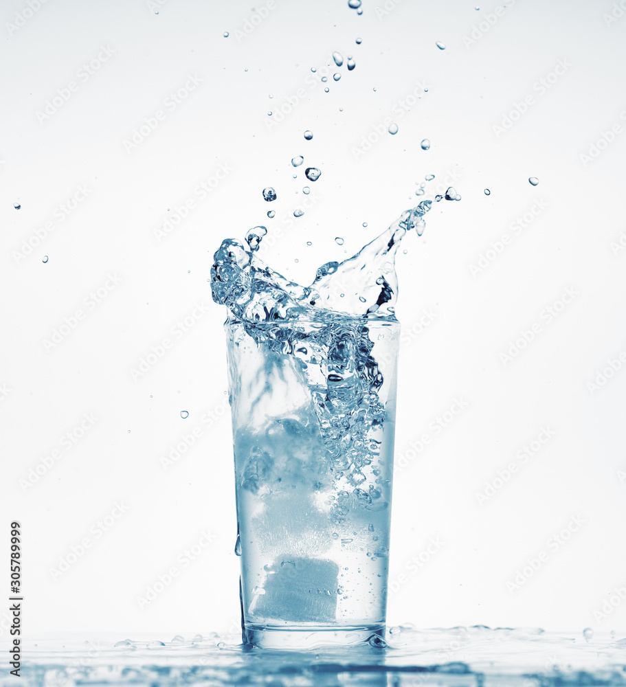 one glass of water with splash from falling ice cube, white background, isolated object one glass of water with splash from falling ice cube, white background, isolated object