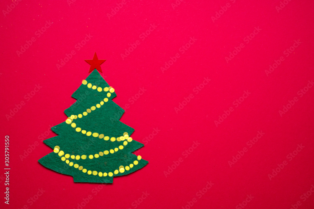 Handmade felt New Year Tree on red paper background. New Year or Christmas background. Handmade felt New Year Tree on red paper background. New Year or Christmas background.