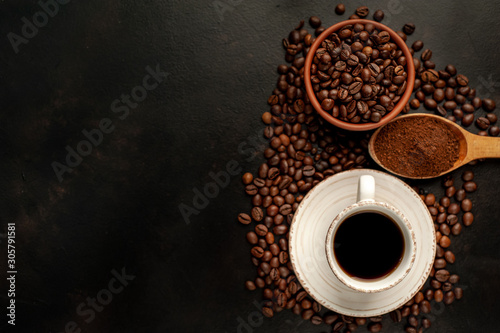 Cup of tasty coffee and beans on a stone background. Top view with copy space for your text.