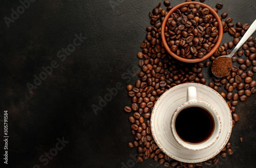 Cup of tasty coffee and beans on a stone background. Top view with copy space for your text.