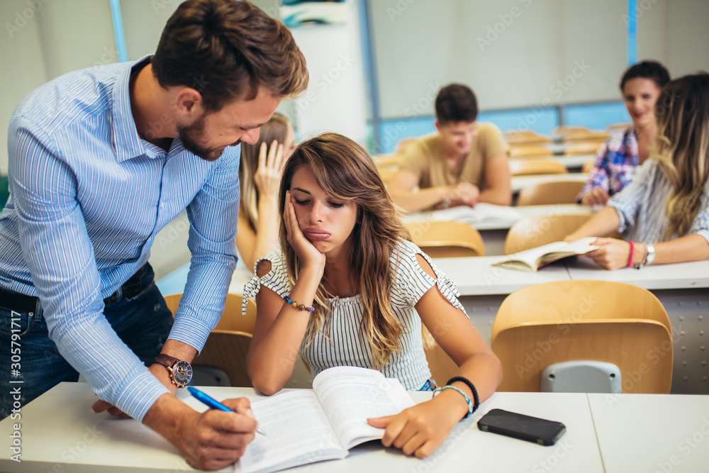 Male tutor teaching university students in classroom. Male tutor teaching university students in classroom.