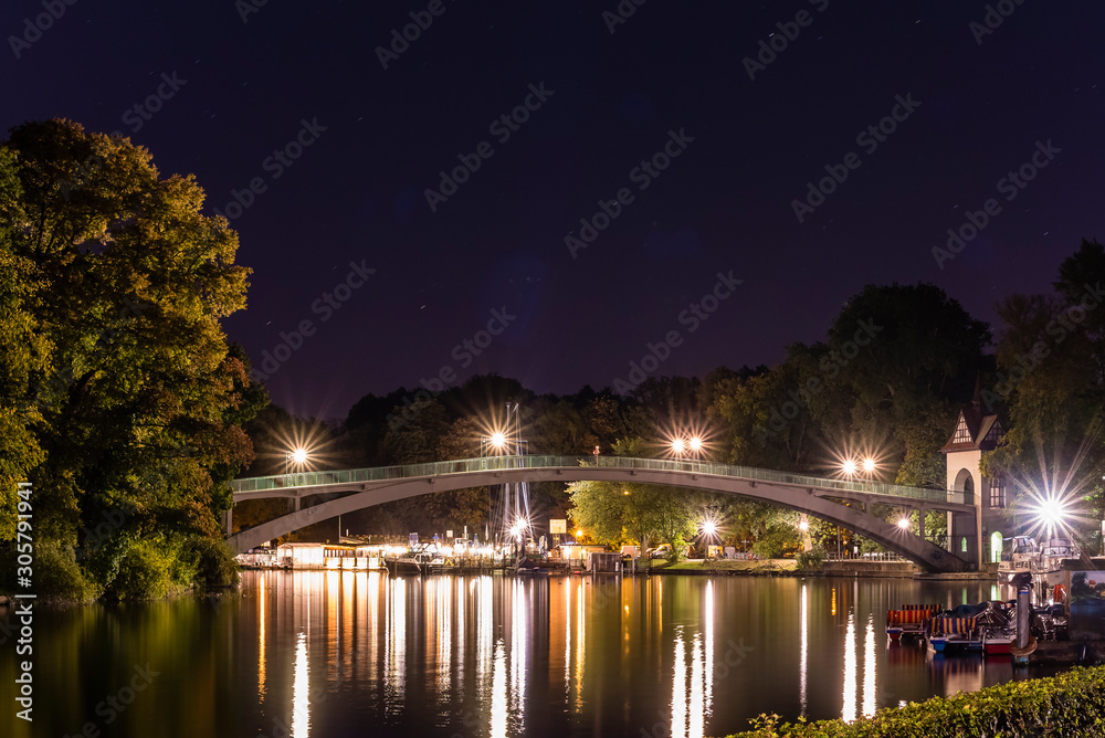 A pedestrian bridge over water at night, Island of Youth, Berlin, Treptower park, bridge at night