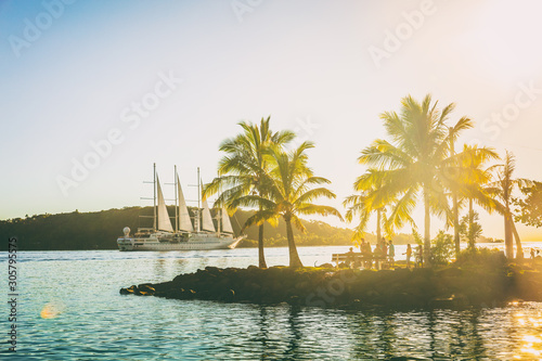 Luxury travel cruise ship sailing away in French Polynesia Tahiti Bora Bora island sunset landscape. Honeymoon famous destination idyllic tropical islands.