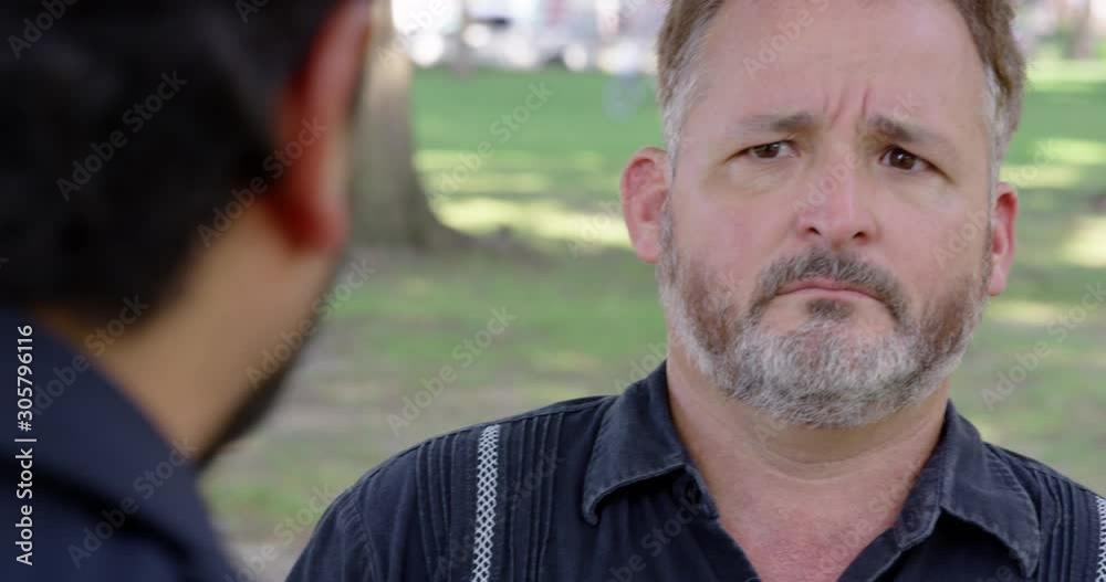 Closeup - A man is being berated by another man while outside at a park - shot on RED Closeup - A man is being berated by another man while outside at a park - shot on RED