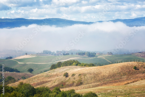 Typical summer rural landscape of Tuscany with hay rolls in the field, Italy