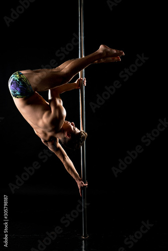 Photo of guy performs acrobatic trick on pole photo