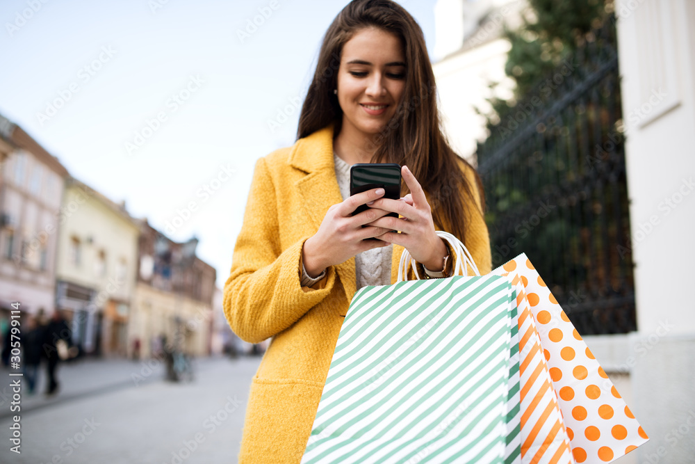 Woman in a yellow coat using mobile