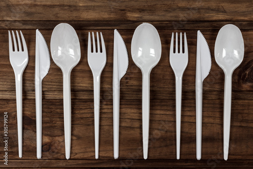 set of plastic cutlery, on a wooden table, copy spaсe