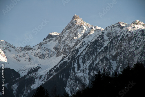 Schneebedeckte Gipfel in den Alpen von Tirol im Ötztal im Winter. Berge und Wald bedeckt mit Schnee. Abendsonne