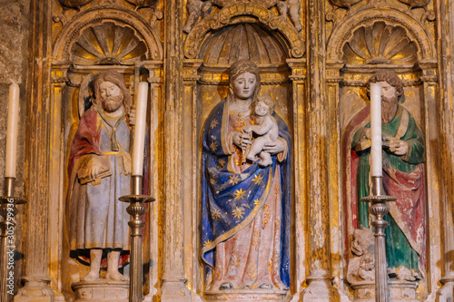 Santiago de Compostela, Spain - 10/14/2018: interior of cathedral of Saint Jacob with old statues and candles. Medieval saint statues. God Mother with Jesus baby and saints. Religious unesco heritage.