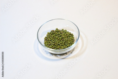 Mung bean seeds in glass bowl isolated on white background