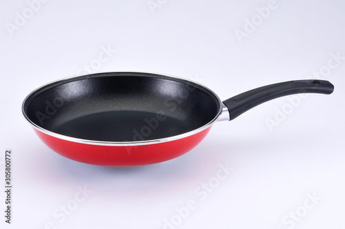 Red pan with black handle on white background