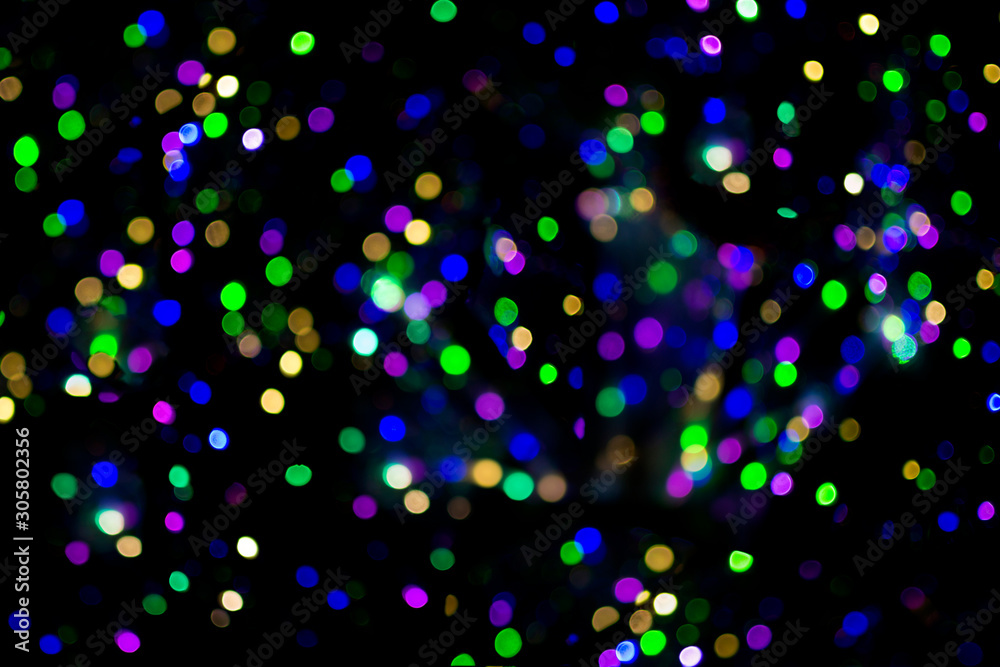 Bokeh background, multi-colored shining lights on a black background. Festive lights, magical abstract texture of sparkl bubbles.