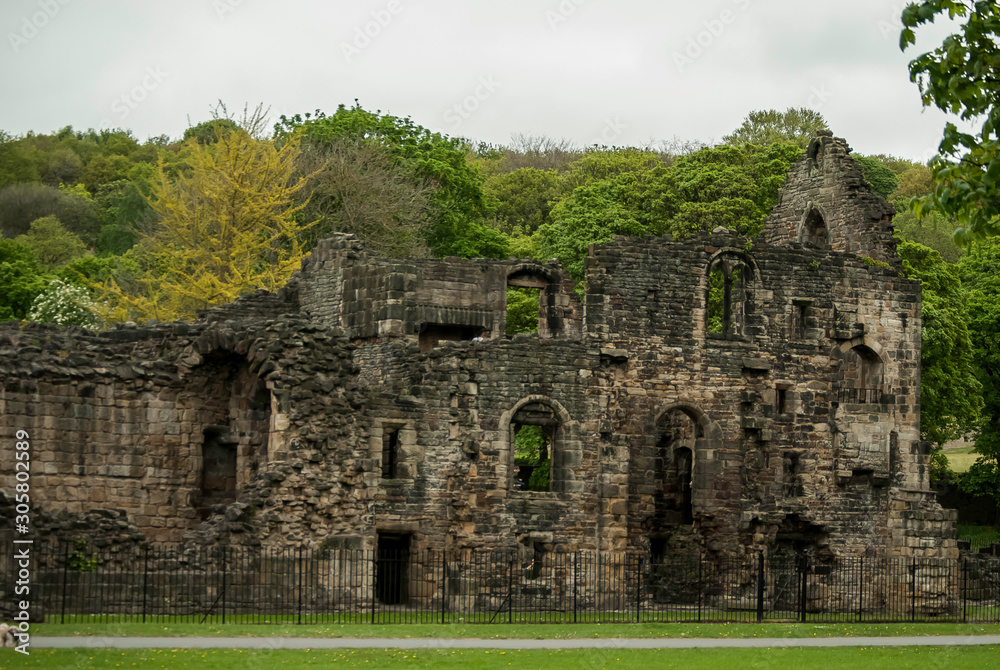 Kirkstall Abbey, Leeds: ruins of the abbey against the backdrop of green trees. Kirkstall Abbey, Leeds: ruins of the abbey against the backdrop of green trees.