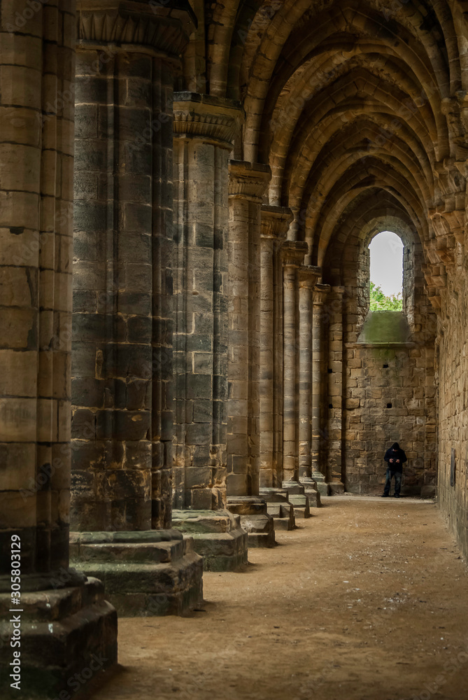 Kirkstall Abbey, Leeds: Visitor in the end of the avenue of columns.