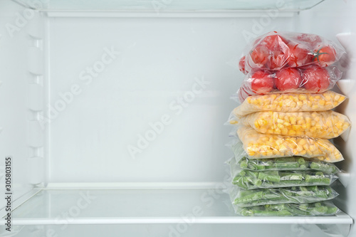 Schilderij op canvas Plastic bags with different frozen vegetables in refrigerator