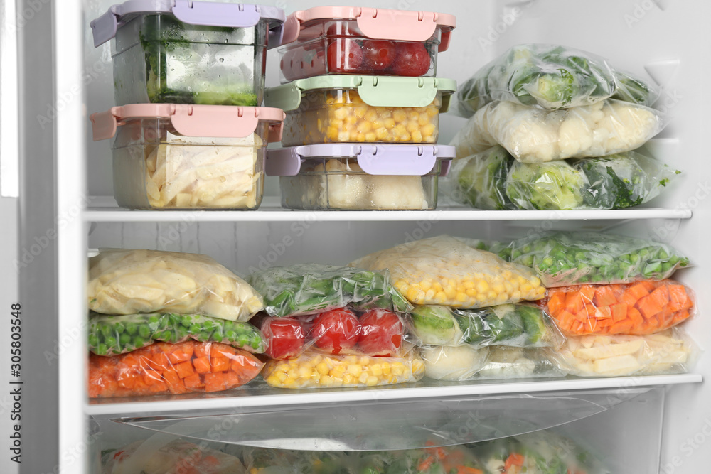 Plastic bags and containers with different frozen vegetables in refrigerator Plastic bags and containers with different frozen vegetables in refrigerator