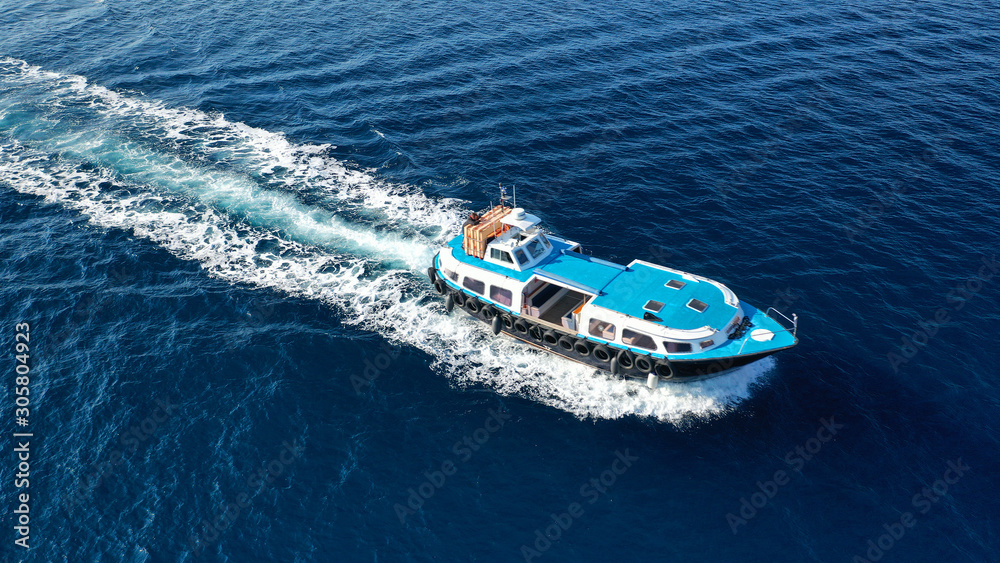 Aerial drone photo of transport vessel cruising in old port of Fira in Santorini island in deep blue sea, Cyclades, Greece
