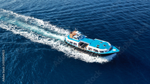 Aerial drone photo of transport vessel cruising in old port of Fira in Santorini island in deep blue sea, Cyclades, Greece © aerial-drone