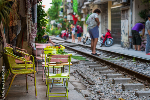 Tables and chairs set up next to the famous train street in Hanoi, ready for when the next train comes through