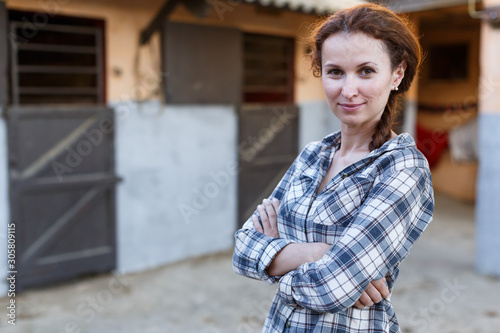 Konstfotografi Mature smiling woman farmer standing  at  stable outdoor