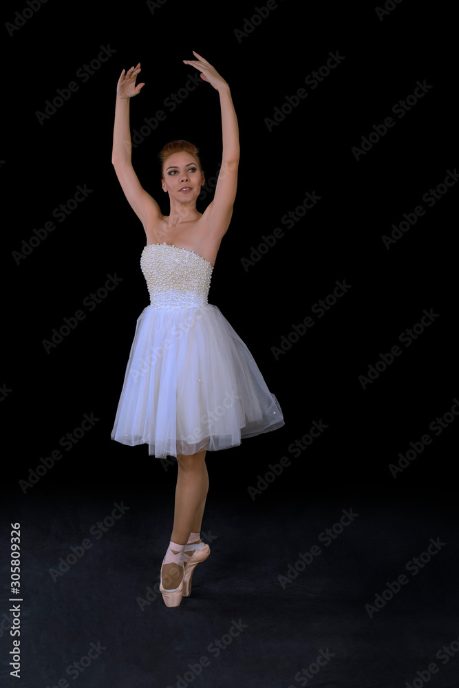 Naklejka premium the ballerina in pointes and a dress dances on a black background
