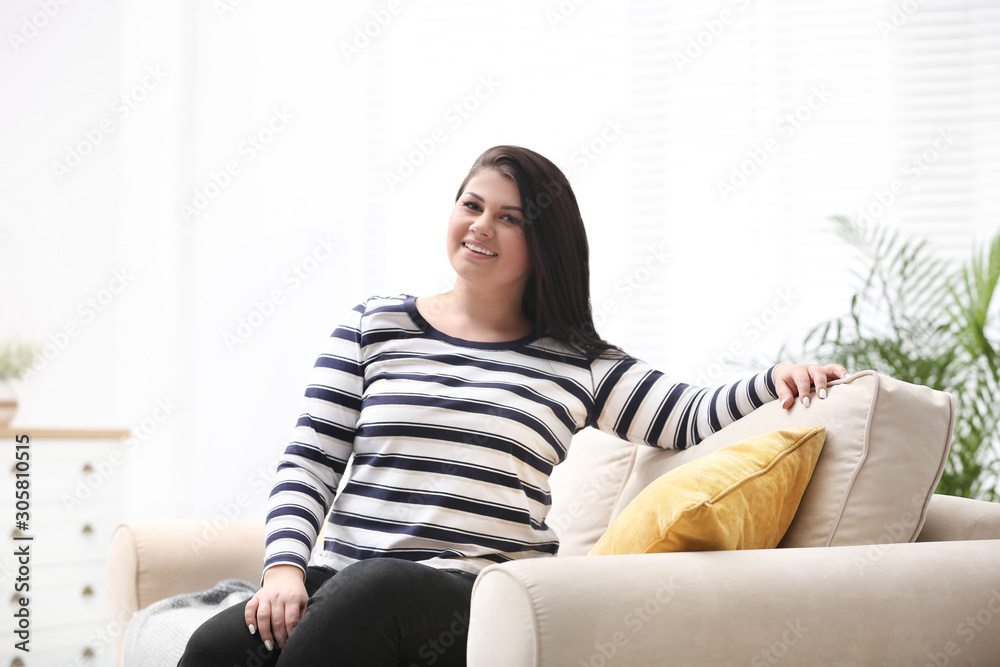 Beautiful overweight woman on sofa in living room. Plus size model Beautiful overweight woman on sofa in living room. Plus size model