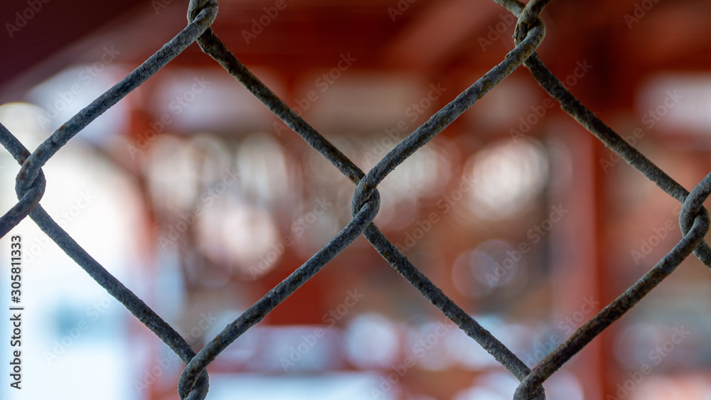Wire fence with blurry background symbolizing togetherness Wire fence with blurry background symbolizing togetherness
