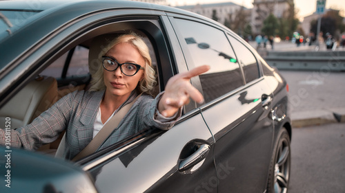 Feeling angry. Portrait of angry business woman gesturing with hands and arguing with somebody while driving a car © Svitlana