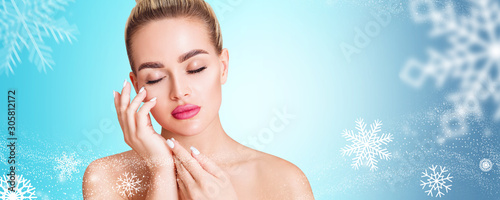 Young woman over blue background with snowflakes. Cryolifting concept. photo