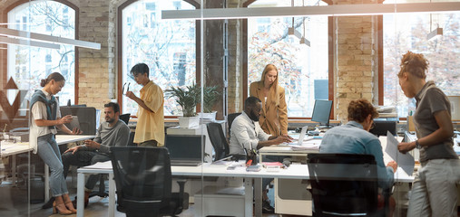 Working together on project. Group of young mixed race business people working together in the creative office. Team building concept. Office life