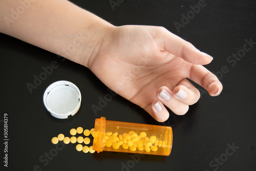 Photo reflecting the perscrition drug crisis. A young person with a container of spilled pills. photo