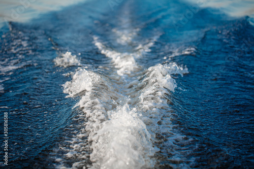 Deep river. Crossing from coast to coast. Very beautiful path on the water behind the stern of the boat from the engine.