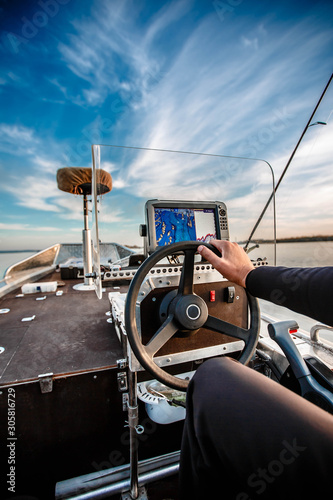 The captain holds the ship's steering wheel on a yacht or catamaran.