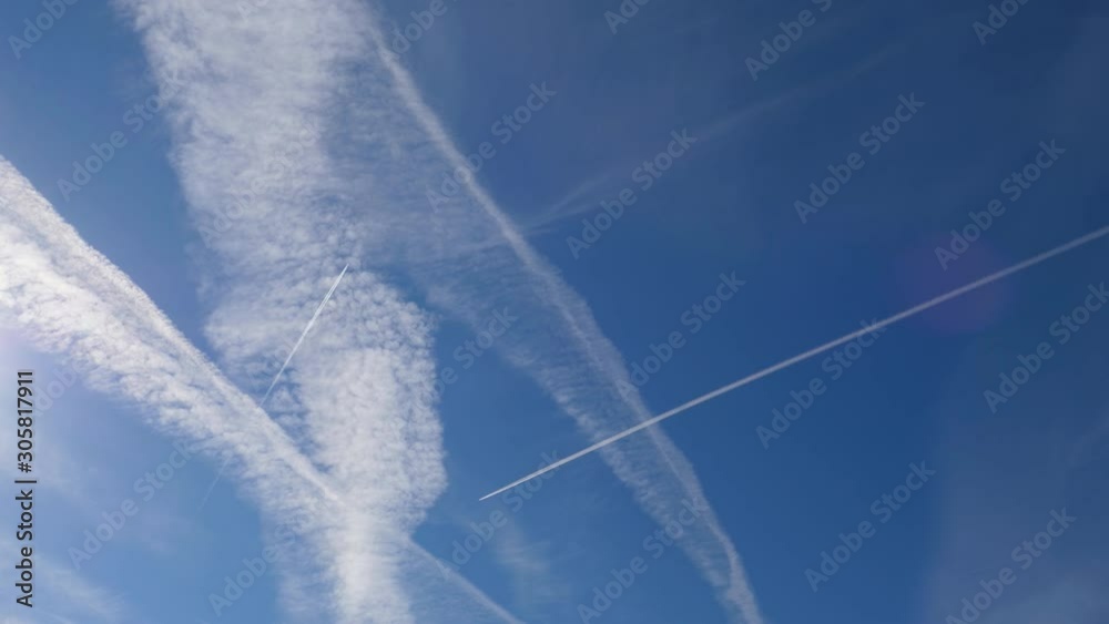 Airplanes and contrails in the blue sky, red lens flare. Airplanes and contrails in the blue sky, red lens flare.