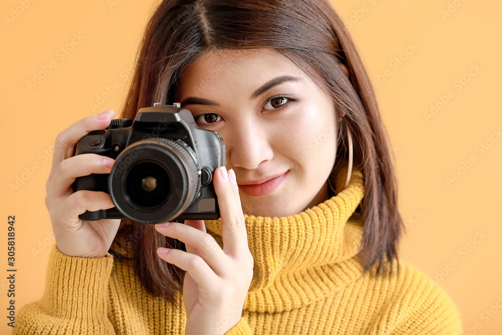 Beautiful Asian photographer on color background
