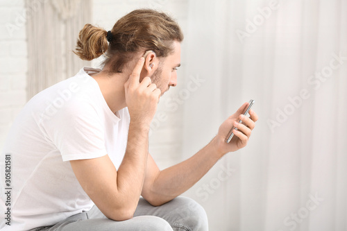 Young man with hearing aid ...