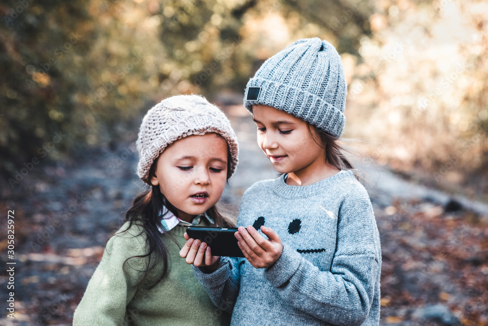 Children in the background of nature play with smartphone. Watch the video and have fun. Friendship Children in the background of nature play with smartphone. Watch the video and have fun. Friendship