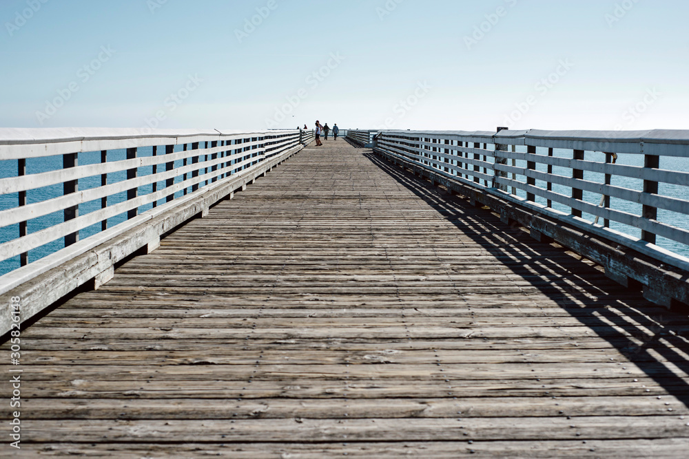 Blue skies and a long wooden pier in San Simeon, CA