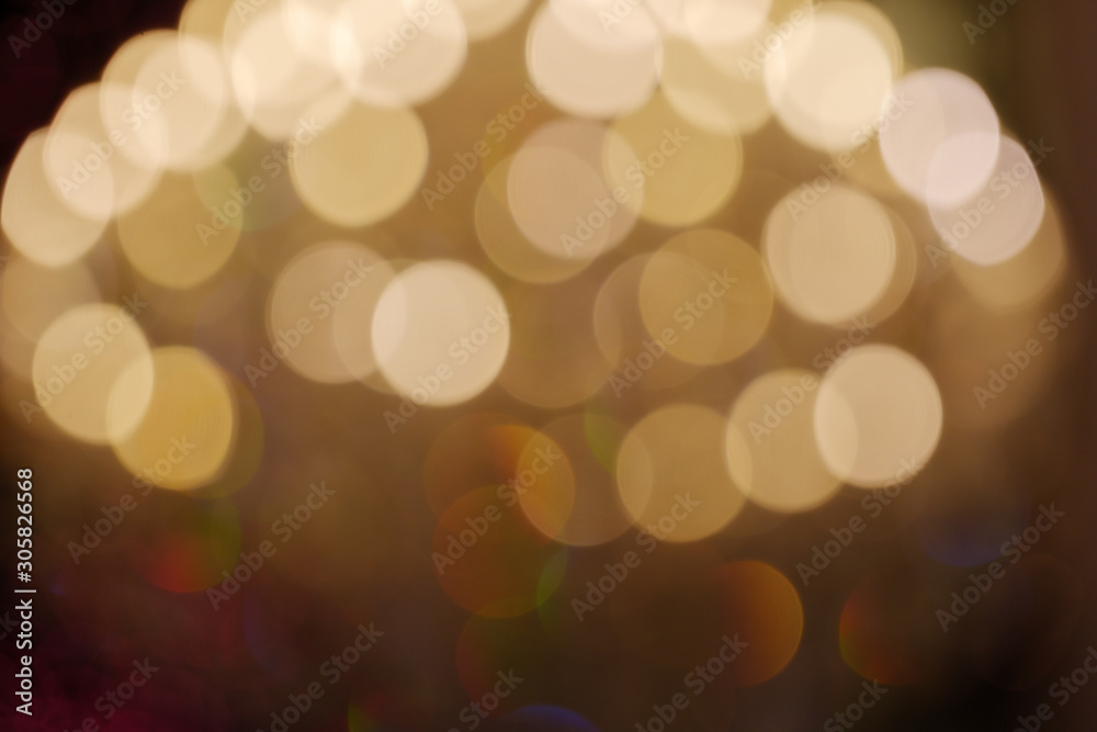 Gold Christmas light shiny abstract round bokeh on dark background. Colourful Glitter bokeh from blurry decoration bulbs.