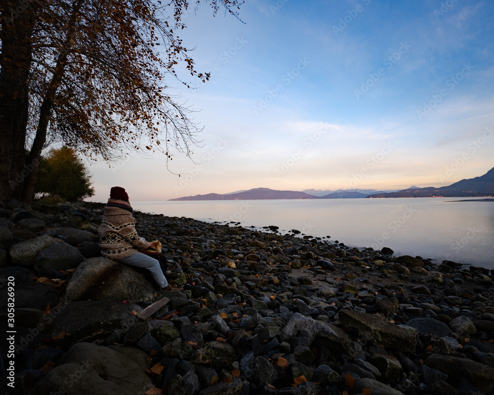 Woman at sunrise on the beach at Spanish Banks, Vancouver, BC.