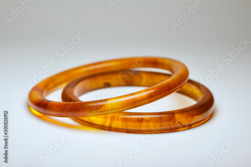 Close up view of a pair of vintage tortoise shell bakelite bangle bracelets on a white background