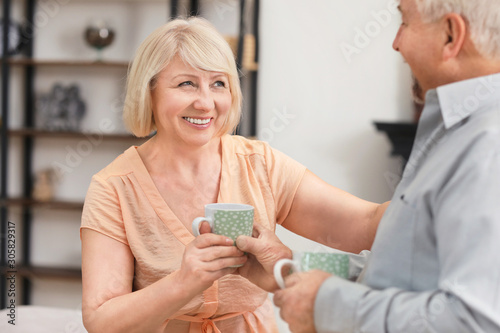 Happy mature couple drinking hot chocolate at home