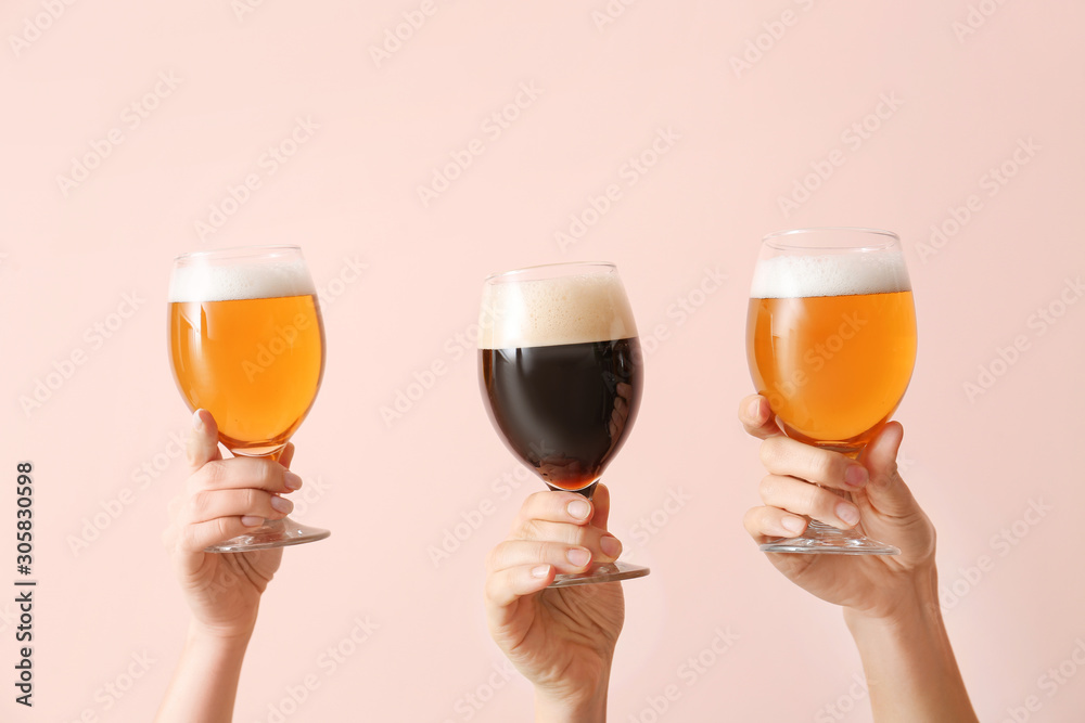 Hands with glasses of beer on color background Hands with glasses of beer on color background