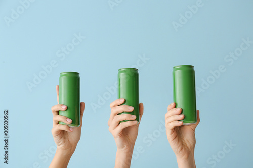 Foto Hands with cans of beer on color background