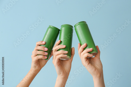 Foto Hands with cans of beer on color background